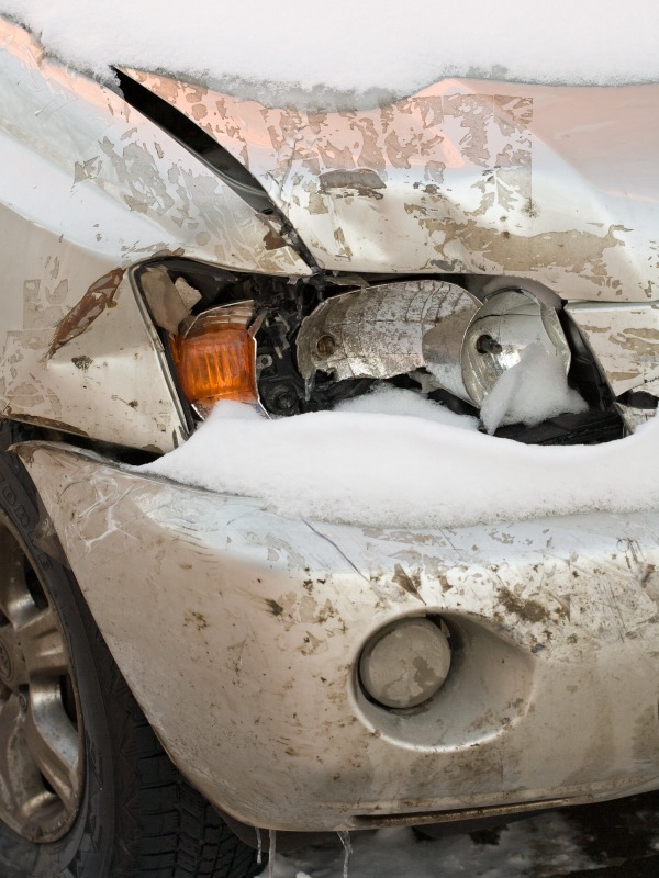 Broken headlight on snow-covered car
